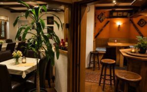 Cozy Verdo Hotel bar corner with wooden stools, warm ambient lighting, and rustic boutique atmosphere.