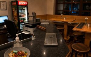 Verdo Hotel bar counter with warm wooden interior, cozy seating, and intimate boutique evening atmosphere.