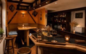Warm boutique-style hotel bar at Verdo Hotel with wooden interior, cozy seating, ambient lighting, and elegant evening atmosphere.