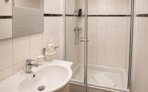 Clean Verdo Hotel double room bathroom with modern sink, glass shower cabin, and bright boutique hotel interior.