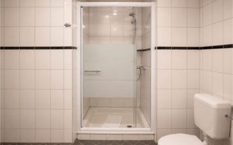 Minimal Verdo Hotel double room bathroom with glass shower cabin, white tiled walls, and clean modern boutique hotel design.