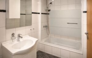 Modern Verdo Hotel double room bathroom with bathtub, glass shower screen, clean sink area, and bright boutique hotel interior.