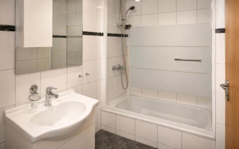Modern Verdo Hotel double room bathroom with bathtub, glass shower screen, clean sink area, and bright boutique hotel interior.