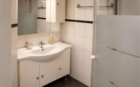 Clean Verdo Hotel deluxe bathroom with modern sink vanity, white tiled walls, and bright boutique hotel interior design.