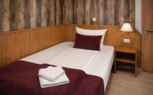 Verdo Hotel deluxe room with comfortable single bed, warm wooden accents, bedside lamp, and cozy boutique hotel atmosphere.