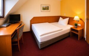 Verdo Hotel deluxe room with comfortable single bed, warm bedside lighting, workspace desk, and cozy boutique hotel interior.