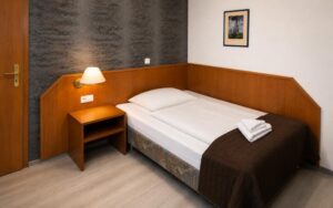 Comfortable deluxe room at Verdo Hotel with warm bedside lighting, wooden furnishings, and clean boutique-style bedroom interior.