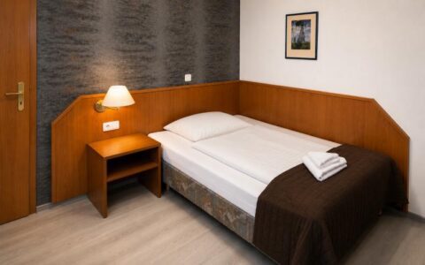 Comfortable deluxe room at Verdo Hotel with warm bedside lighting, wooden furnishings, and clean boutique-style bedroom interior.