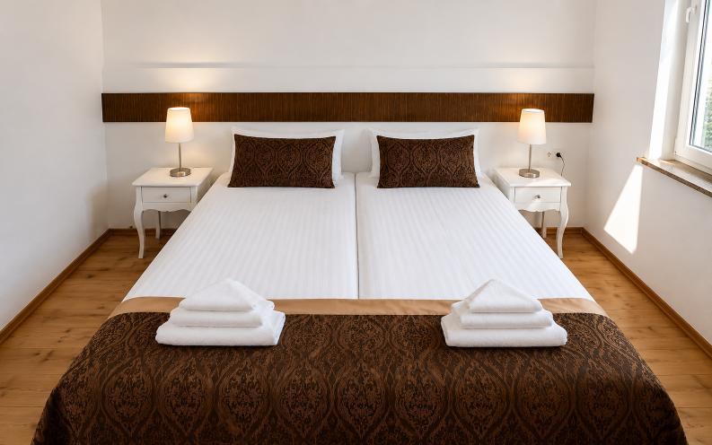 Minimal boutique hotel double room at Verdo Hotel with white bedding, warm bedside lighting, wooden accents, and cozy European interior design.