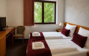 Verdo Hotel double room with two comfortable single beds, natural daylight, workspace desk, and cozy boutique hotel atmosphere.