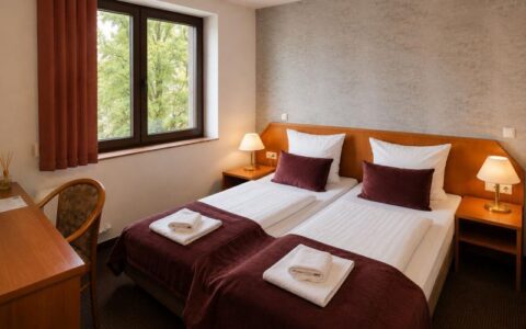 Verdo Hotel double room with twin beds, warm bedside lighting, workspace desk, and cozy boutique hotel atmosphere.
