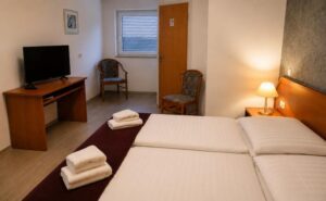 Verdo Hotel double room with twin beds, warm bedside lighting, TV area, and comfortable boutique hotel interior.