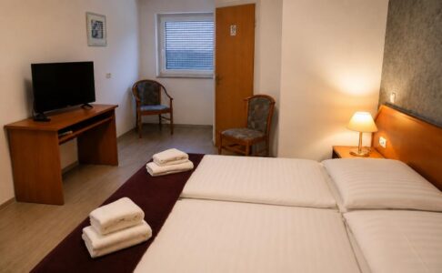 Verdo Hotel double room with twin beds, warm bedside lighting, TV area, and comfortable boutique hotel interior.