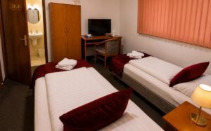 Verdo Hotel double room with twin beds, warm bedside lighting, TV area, and cozy boutique hotel atmosphere.