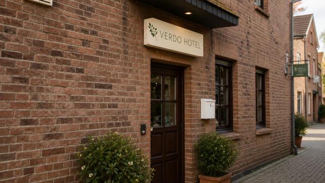 Exterior entrance of Verdo Hotel with traditional brick architecture and boutique European hotel atmosphere.