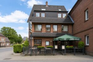 Front exterior view of Verdo Hotel with outdoor terrace seating, brick architecture, and welcoming boutique hotel atmosphere in Germany.