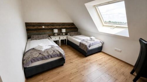 Verdo Hotel family room with two single beds, sloped ceiling, natural daylight, and clean minimalist boutique interior.