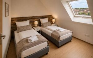 Bright Verdo Hotel family room with two single beds, sloped ceiling window, natural daylight, and cozy boutique interior design.