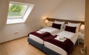 Comfortable Verdo Hotel family room with twin beds, soft lighting, sloped ceiling window, and warm boutique-style interior.