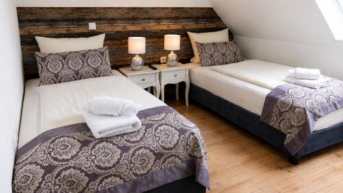 Spacious Verdo Hotel family room with twin beds, warm bedside lighting, wooden accents, and comfortable boutique-style interior.