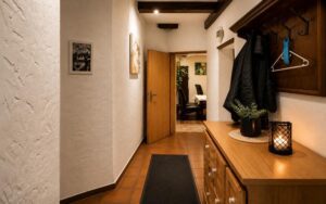Warm hallway interior at Verdo Hotel with wooden furniture, soft ambient lighting, decorative mirror, and cozy boutique atmosphere.