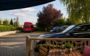 Outdoor parking area at Verdo Hotel with guest vehicles, terrace seating, greenery, and a calm boutique hotel atmosphere.