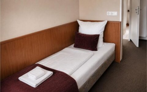 Verdo Hotel single room with comfortable single bed, warm wooden accents, and clean modern boutique hotel interior.
