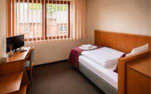 Verdo Hotel single room with comfortable single bed, workspace desk, natural daylight, and clean boutique hotel interior.