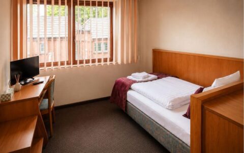 Verdo Hotel single room with comfortable single bed, workspace desk, natural daylight, and clean boutique hotel interior.